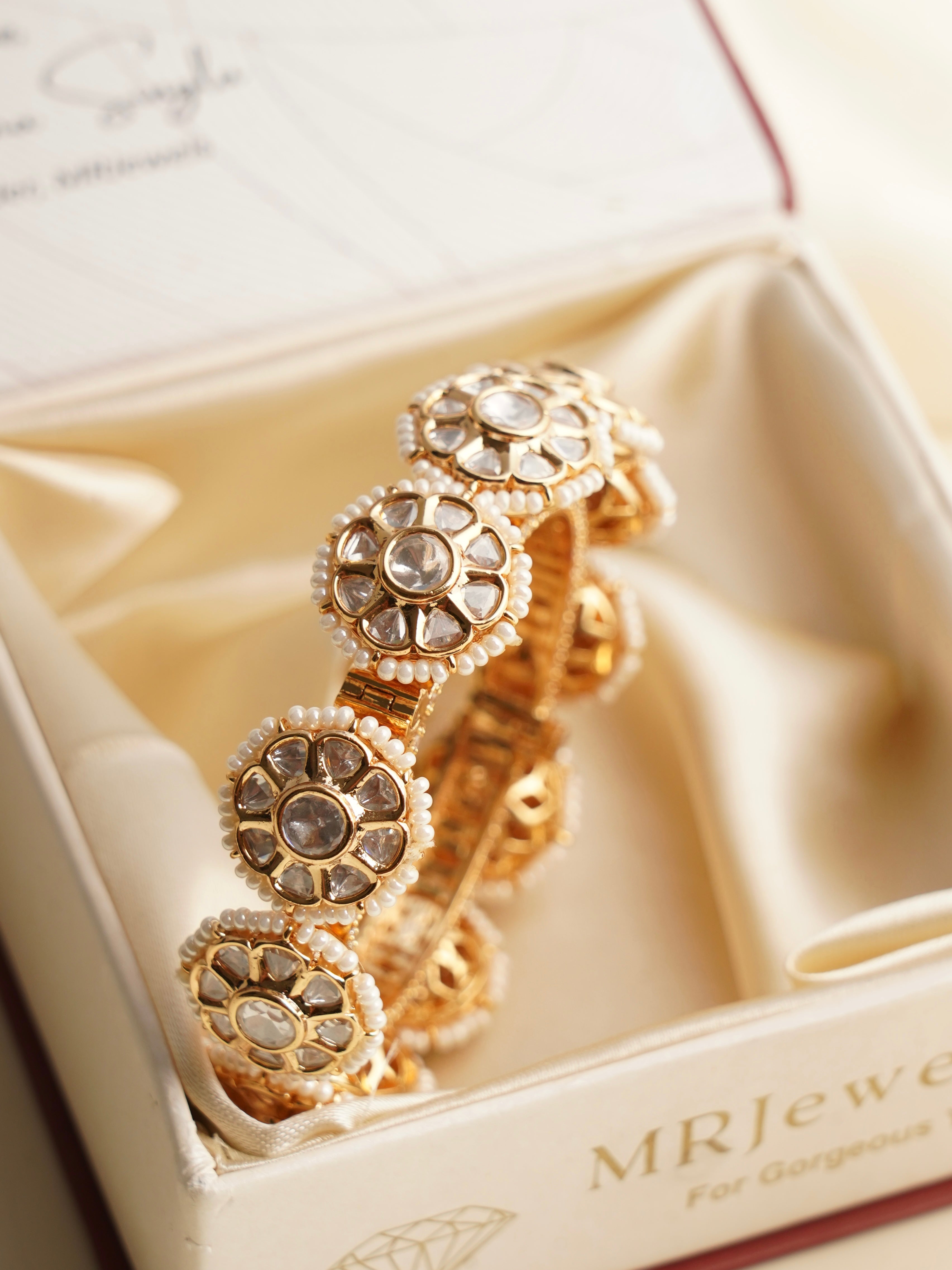 Side view of gold kundan bangles featuring floral pearl detailing in a heritage-inspired design